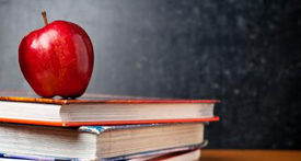 Books and Apple in front of Chalk Board